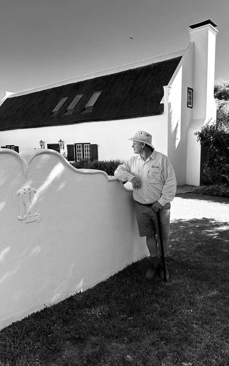 Rob Caskie leaning on a whitewashed Cape Dutch wall